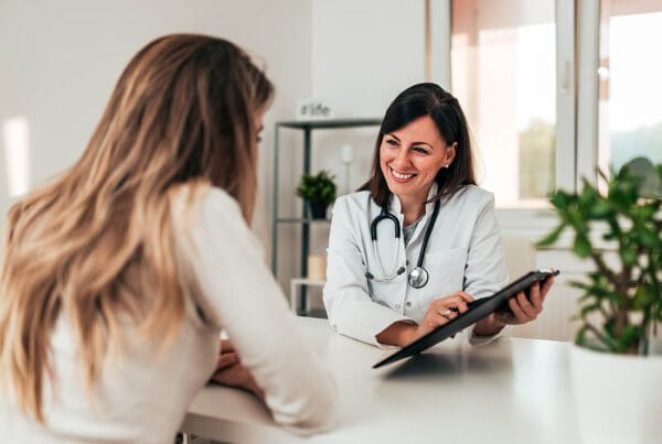 Group Health Insurance - Doctor Consulting Young Patient at the Doctors Office